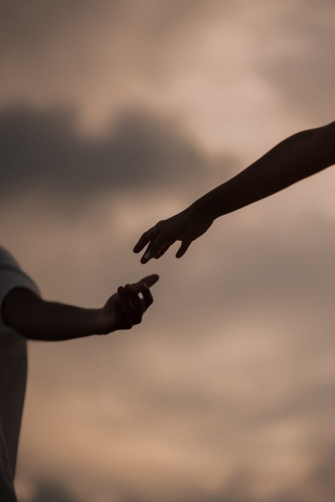 Crafting Captivating Headlines: Your awesome post title goes here Silhouette of two hands reaching towards each other at sunset, symbolizing connection and hope.
