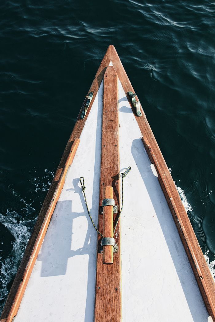 Top view of a wooden boat sailing in the clear waters of Bretagne, France.